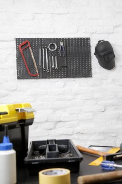 Masada aletler ve duvarda plastik tahta olan boş bir atölye