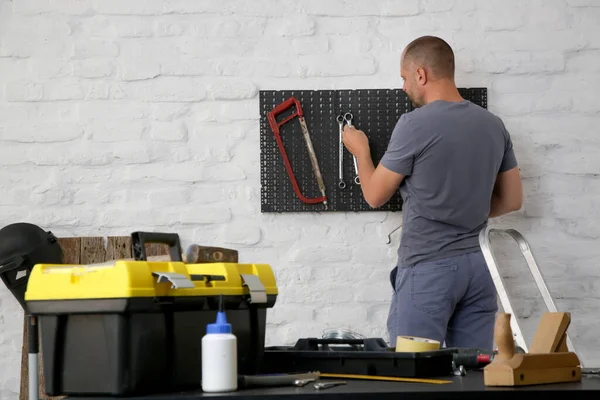 Mann Organisiert Werkstatt Sein Werkzeug Auf Dem Kunststoffhebel Der Wand — Stockfoto