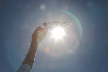 Coronavirus bitti. Karantina ve Corona Virüsü salgınının sonu. Kadın kalkıyor ve tıbbi koruyucu maskeyi atıyor. Coronavirüs salgınından sonra hayatın ve temiz havanın tadını çıkarıyorum.. 