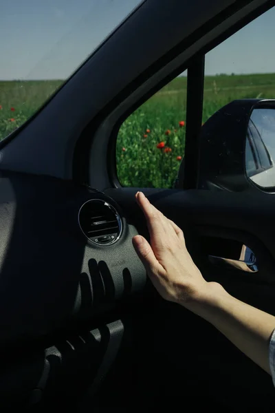 Hand checking the air conditioner in the car