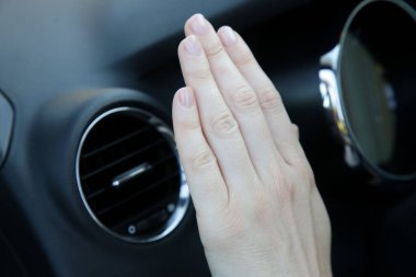 Arabadaki klimayı elle kontrol ediyorum.