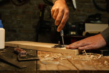 Marangoz atölyedeki tahta üzerinde metal krom vidalama menteşeleri.