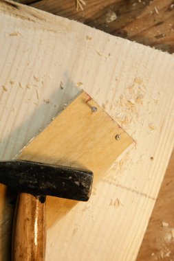 Marangoz aletleri, çekiç ve ahşap tahtalarla ahşap masa manzarası.