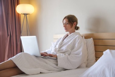 Genç yazar, blogcu, serbest çalışan ya da yatakta oturup dizüstü bilgisayarla çalışan öğrenci portresi