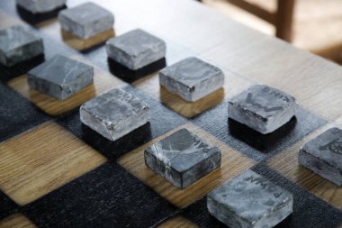 Tahtada asgari tasarım taş satranç figürleri