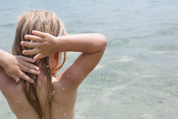 一个带着一头长长的金发的小女孩在海滩上 后视镜 咸咸的海水和阳光造成的头发损害 夏季护发概念 — 图库照片