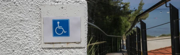 Blue square handicapped wheelchair accessible symbol on the wall