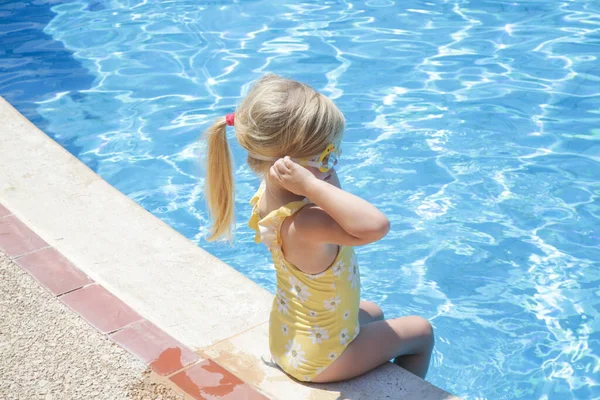 Κοριτσάκι Κίτρινο Μαγιό Που Κάθεται Στην Άκρη Της Πισίνας — Φωτογραφία Αρχείου