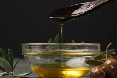 Bir kaseye ekstra saf zeytinyağı döken bir kadın. Geleneksel Akdeniz ev yapımı yağı.