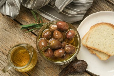 Zeytin, zeytin yağı ve ekmek ahşap kırsal masada..