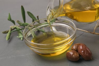 Bir kaseye ekstra saf zeytinyağı döken bir kadın. Geleneksel Akdeniz ev yapımı yağı.