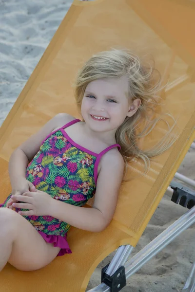 Αξιολάτρευτο Κοριτσάκι Που Κάθεται Ξαπλώστρα Στην Παραλία Της Άμμου Ευτυχισμένο — Φωτογραφία Αρχείου