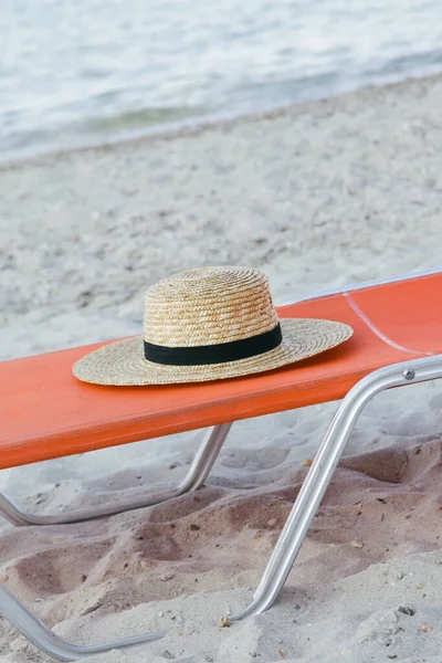 砂のビーチで帽子とオレンジの日なたぼっこは 牧歌的で静かな夏の休暇のコンセプト — ストック写真