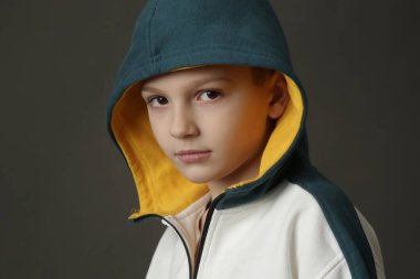 Gri arka planda yakışıklı okul çocuğunun stüdyo portresi..