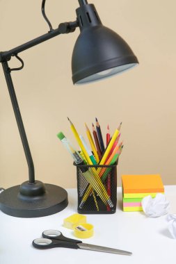 Eğitim ve okul kavramı: masa lambası, not defterleri ve okul kırtasiyesi.