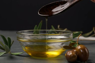 Bir kaseye ekstra saf zeytinyağı döken bir kadın. Geleneksel Akdeniz ev yapımı yağı.