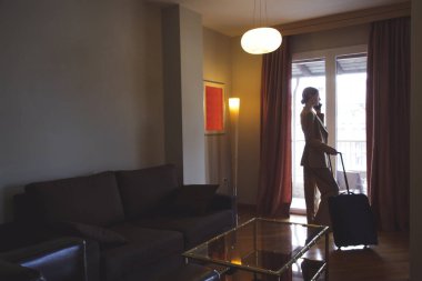 İş seyahati. Otel odasında çalışan genç bir iş kadını..