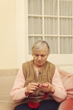 Yaşlı kadın ile kırmızı yün örgü