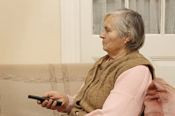 Dame âgée avec télécommande — Photo