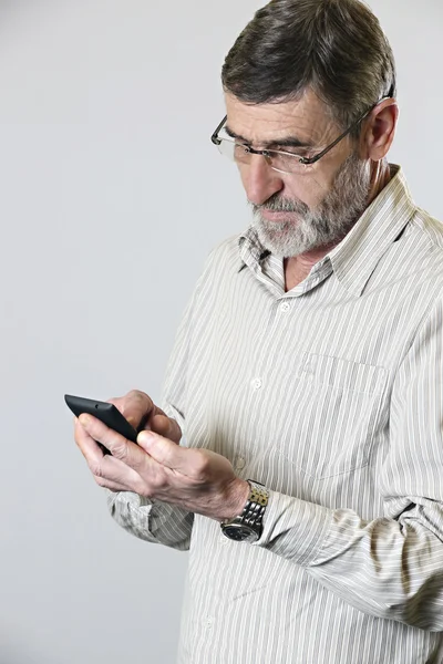 Połowie wieku człowiek patrząc na swój telefon — Zdjęcie stockowe