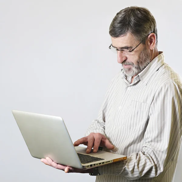 Hombre mayor con un ordenador portátil — Foto de Stock