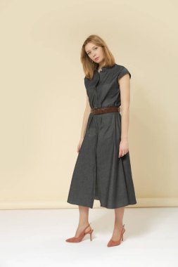 Kemerli, minimalist moda koleksiyonu olan, deniz mavisi kot Midi elbise giyen kadın model bir resim.