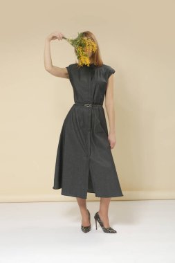 Kemerli, minimalist moda koleksiyonu olan, deniz mavisi kot Midi elbise giyen kadın model bir resim.