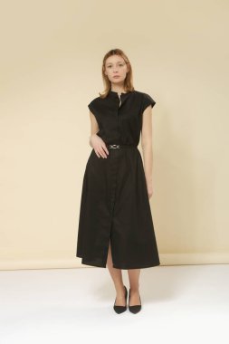 Siyah Midi elbisesi ve zarif minimalist moda koleksiyonu giyen kadın model portresi.