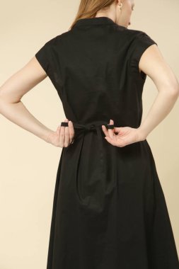 Siyah Midi elbisesi ve zarif minimalist moda koleksiyonu giyen kadın model portresi.