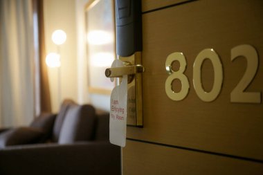 Otelin kapı askısı. Lütfen oda etiketimi kapı kolunda asılı olarak temizle.