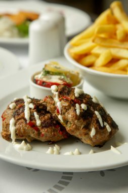 Patates kızartması ve biberle servis edilen baharatlarla ızgara kıyma.