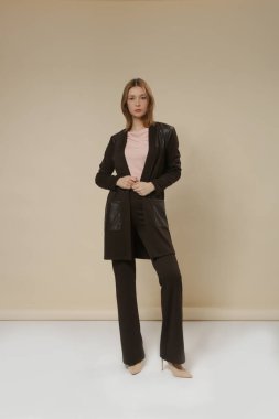 Sıradan giyinen kadın model- Pamuk pembesi gömlek, pamuk ve deri düğmesiz Cardigan yama paketleri ve deri pantolon. Stüdyo çekimi.