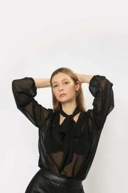 Stüdyo fotoğrafları, siyah elbiseli genç kadın modelin portresi, katıksız bluz ve deri pantolon..