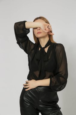 Stüdyo fotoğrafları, siyah elbiseli genç kadın modelin portresi, katıksız bluz ve deri pantolon..