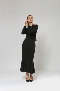 Blink tişört giyen ve mini etek giyen kadın model stüdyo resmi ve zarif minimalist moda koleksiyonu.