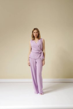 Çamaşır takımı, kolsuz bluzu ve rahat pantolonu olan genç bir kadının stüdyo fotoğrafları. Gündelik ve şık kıyafetler, bahar-yaz moda trendi.