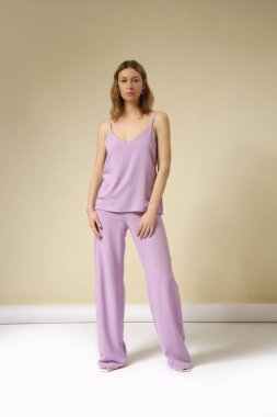 Çamaşır takımı, kolsuz bluzu ve rahat pantolonu olan genç bir kadının stüdyo fotoğrafları. Gündelik ve şık kıyafetler, bahar-yaz moda trendi.