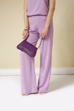 Çamaşır takımı, kolsuz bluzu ve rahat pantolonu olan genç bir kadının stüdyo fotoğrafları. Gündelik ve şık kıyafetler, bahar-yaz moda trendi.