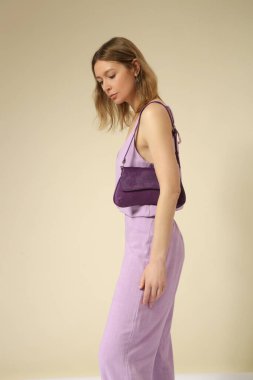 Çamaşır takımı, kolsuz bluzu ve rahat pantolonu olan genç bir kadının stüdyo fotoğrafları. Gündelik ve şık kıyafetler, bahar-yaz moda trendi.