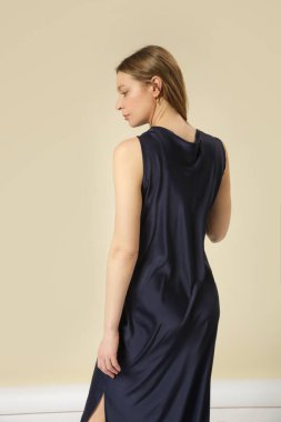 Stüdyo fotoğraflarında koyu mavi ipek elbise giyen kadın modeller var. Zarif asgari moda.