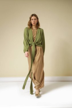 Bej Maxi elbise ve yeşil uzun kollu muslin kaplı genç kadın modelin seri fotoğrafları. Gündelik ve şık yaz kıyafetleri, bahar-yaz moda trendi.