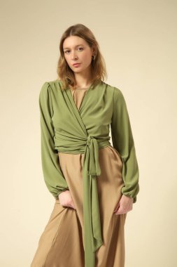 Bej Maxi elbise ve yeşil uzun kollu muslin kaplı genç kadın modelin seri fotoğrafları. Gündelik ve şık yaz kıyafetleri, bahar-yaz moda trendi.