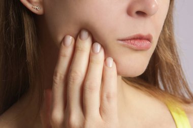 Diş ağrısı olan genç kadının stüdyo çekimi, yakın çekim