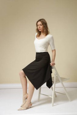 Beyaz pamuklu gömlek giyen kadın manken ve siyah asimetrik etek sıradan moda koleksiyonu.