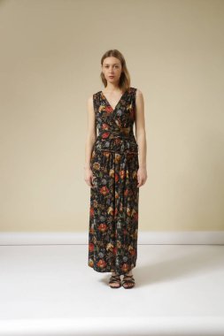 Koyu renk kolsuz Maxi elbise giymiş genç bir kadın modelin seri fotoğrafları. Gündelik ve şık yaz kıyafetleri, bahar-yaz moda koleksiyonu.