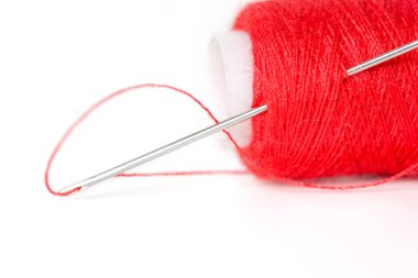 Beyaz arka plan ile kırmızı iplik dikiş iğnesi