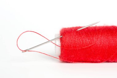 Beyaz arka plan ile kırmızı iplik dikiş iğnesi