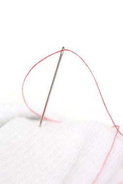 Beyaz arka plan ile kırmızı iplik dikiş iğnesi