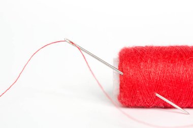 Beyaz arka plan ile kırmızı iplik dikiş iğnesi