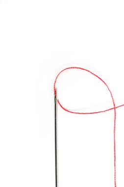 Beyaz arka plan ile kırmızı iplik dikiş iğnesi